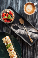 top view of sweet delicious desserts and cup of coffee on wooden table