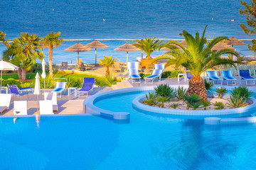 Beautiful luxury outdoor swimming pool with umbrellas and chairs