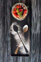 top view of sweet gourmet fruity dessert and spoon on wooden table