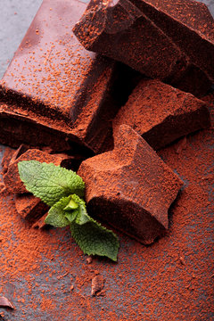 Dark chocolate stack, and powder. With leaf of mint.Closeup.Chocolate