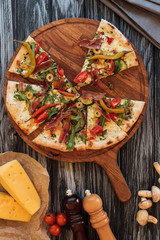 top view of slices of pizza on wooden cutting board