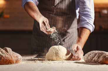 Hands of baker kneading dough - obrazy, fototapety, plakaty