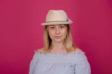 Pretty woman  in straw hat and blue dress isolated on pink background. Beautiful young women, lifestyle portrait. Summer vacation, holidays concept. Attractive blonde girl