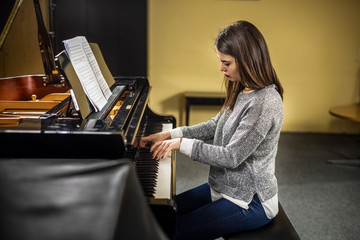 Young woman playing the grand piano