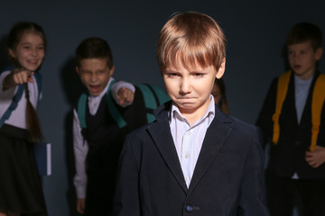 Children bullying their classmate on dark background