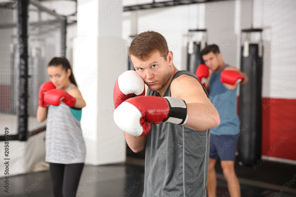 Poster young boxers warming up before training in gym