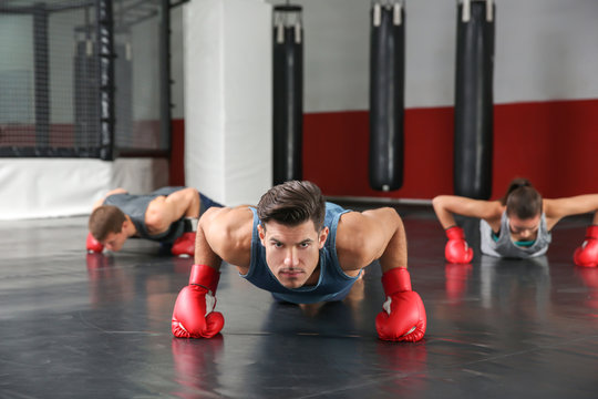 Young boxers warming up before training in gym