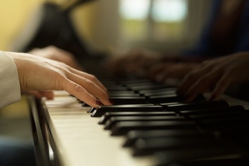 Obraz premium Two young women play on the piano