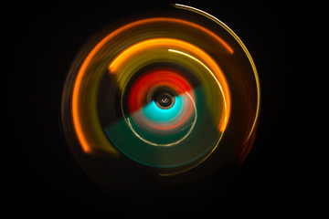 Music concept. Freezelight glowing vinyl on dark background or Turntable playing vinyl with glowing abstract lines concept on dark background.