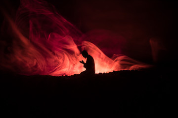 Silhouette of praying Muslim man on toned foggy background. Ramadan Kareem background. Muslim Eid...