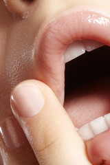 Moisturizing lip balm, lipstick. Close-up beautiful sexy wet lips. Full lips with gloss lip makeup. Filler Injections
