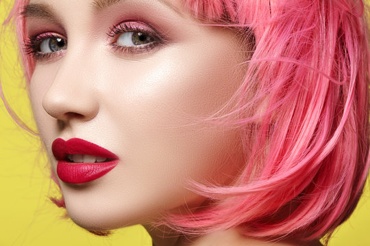 Young woman in pink wig. Beautiful model with fashion makeup. Bright spring look. Sexy hair color, medium hairstyle