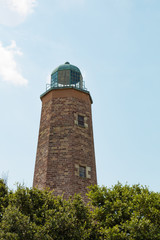 Fototapeta premium The upper half of the Old Cape Henry Lighthouse on a sunny summer day. Built in 1792, it is located on the Fort Story military base.