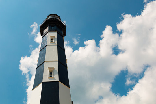 The New Cape Henry Lighthouse, with a background of a partly cloudy sky, stands the southern entrance to Chesapeake Bay on the Fort Story military base.