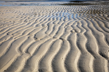 Wave the sandy beach in the morning with a shine to show the surface of the sandy delicate.