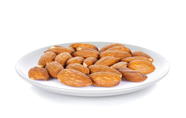 Almond seeds in white plate on white background