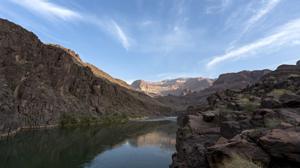 Fototapeta na wymiar Campsite at dawn. Colorado River runs through Grand Canyon providing exciting whitewater rafting and incredible views along the way. Numerous side canyons can be hiked, often to beautiful waterfalls.