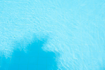 palm shadow in blue swimming pool water  on sunny day 