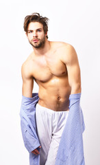 Fototapeta premium Muscular guy with torso takes off blue bathrobe.