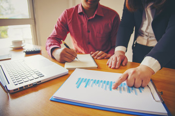 Business meeting, man's hands pointing on charts. Reflection light and flare. Concept image of data gathering and statistical working.