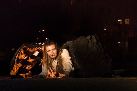 Woman with black wings in night city