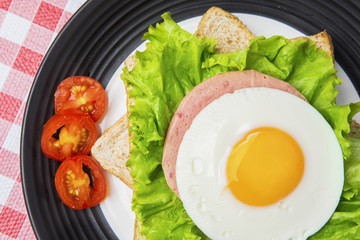 Egg sandwich decorated with sliced tomato