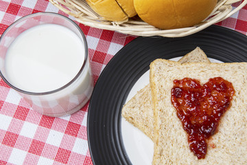 Milk with breads and strawberry jam