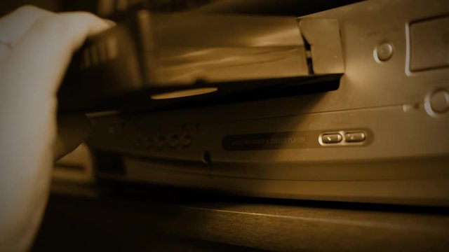 Inserting A VHS Tape Into VHS Player - Old Retro Color Graded Sepia Concept ALT ANGLE