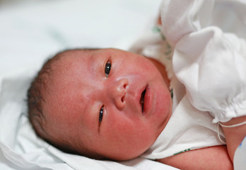 Face of Newborn Asian baby in the blanket.