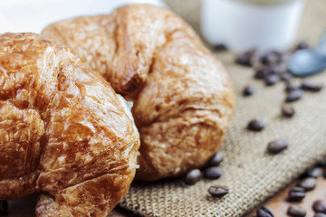 Croissant and coffee on sack.