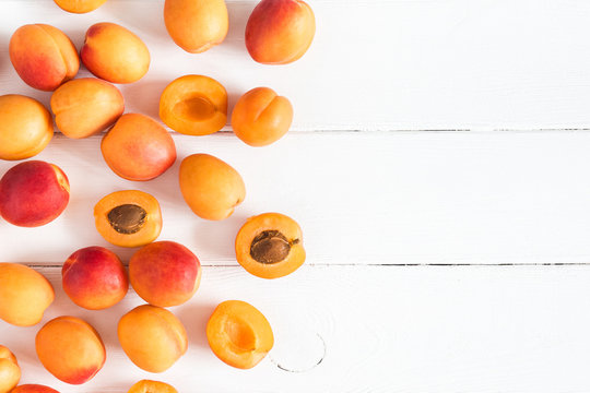 Apricots on white wooden background. Flat lay, top view, copy space