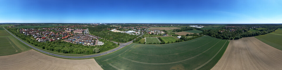 Aerial view of the eastern edge of Wolfburg, with fields and meadows in the foreground and two districts at the back.