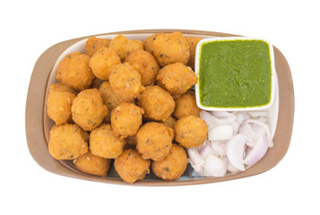 Indian Spicy Street Food Dal Vada Also Know as Moong Dal Vada, Pakoda, Pakode, Pakore, Moong Vada, Pakora or Bhajiya Served with Green Chutney or Onion isolated on White Background