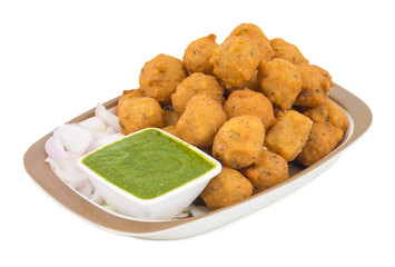 Indian Spicy Street Food Dal Vada Also Know as Moong Dal Vada, Pakoda, Pakode, Pakore, Moong Vada, Pakora or Bhajiya Served with Green Chutney or Onion isolated on White Background