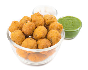 Indian Spicy Street Food Dal Vada Also Know as Moong Dal Vada, Pakoda, Pakode, Pakore, Moong Vada, Pakora or Bhajiya Served with Green Chutney or Onion isolated on White Background