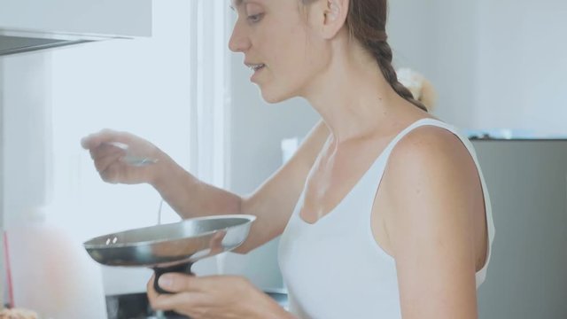 Young woman tasting her soup in a funny disgusting bad taste face expression