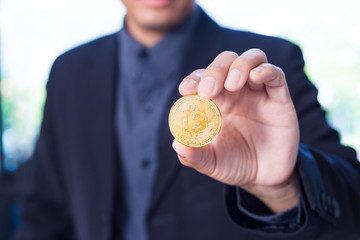 Businessman holding a Bitcoin, cryptocurrency coin in his hand