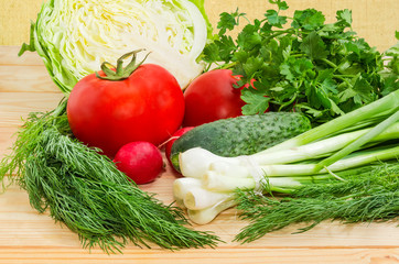 Various fresh vegetables and herbs on a wooden surface