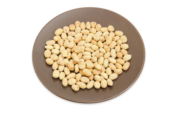 Roasted salted peanuts on brown dish on a white background