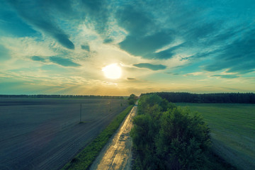 Aerial view of a country road at sunset. Rural evening landscape