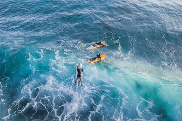 Surfer on a surfboard in the water, top view