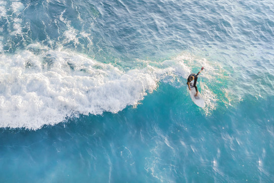 Surfer at the top of the wave in the ocean, top view