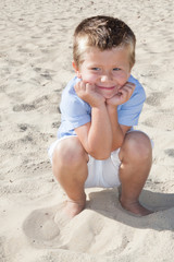 fun little boy sit on sand beach during vacation day summer