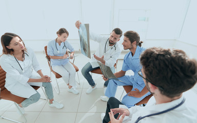 radiologists and a surgeon discussing a radiograph of a patient