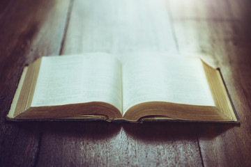 open bible with Blurred page on wooden table, Copy space