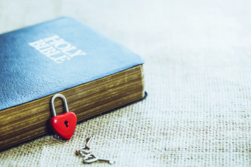 The compass lean on holy bible with Red heart key lock on wooden table. christian background or concept show the word of God is the compass of life. copy space