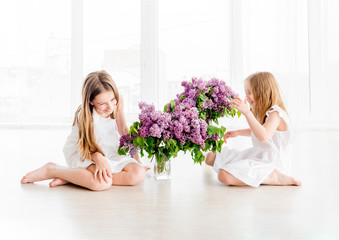 Smiling child girls with lilac bouquet