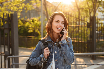 Cheerful woman outdoors talking by mobile phone