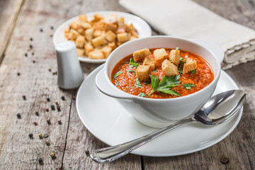 Tomato soup on a table of old wooden boards. Copy-space.