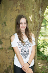 cute young teenager girl against tree in summer day